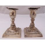 A pair of Victorian hallmarked silver dwarf candlesticks, spirally fluted on stepped square bases,