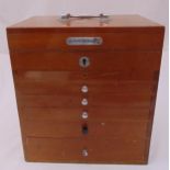 A mid 20th century rectangular oak dentist cabinet with hinged cover and seven drawers, 36.5 x 33