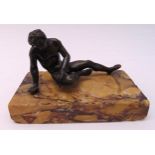 A bronze figurine of a man seated on a marble plinth, 13cm (w)