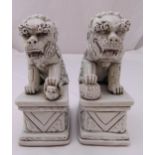 A pair of Chinese blanc de chine male and female Dehua lions on raised rectangular bases,