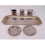 A quantity of silver and white metal to include a three piece condiment set, two coasters and a