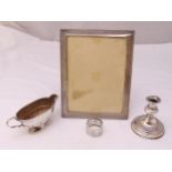 Four pieces of hallmarked silver to include a sauce boat, photograph frame, a napkin ring and a