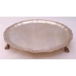 A hallmarked silver salver, circular with Celtic border on four ball and claw feet, London 1931,
