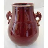 A Chinese ox blood red glazed baluster vase with side handles, marks to the base, 26cm (h)