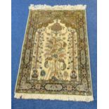 A Persian wool and silk carpet light brown ground with tree of life design and repeating floral