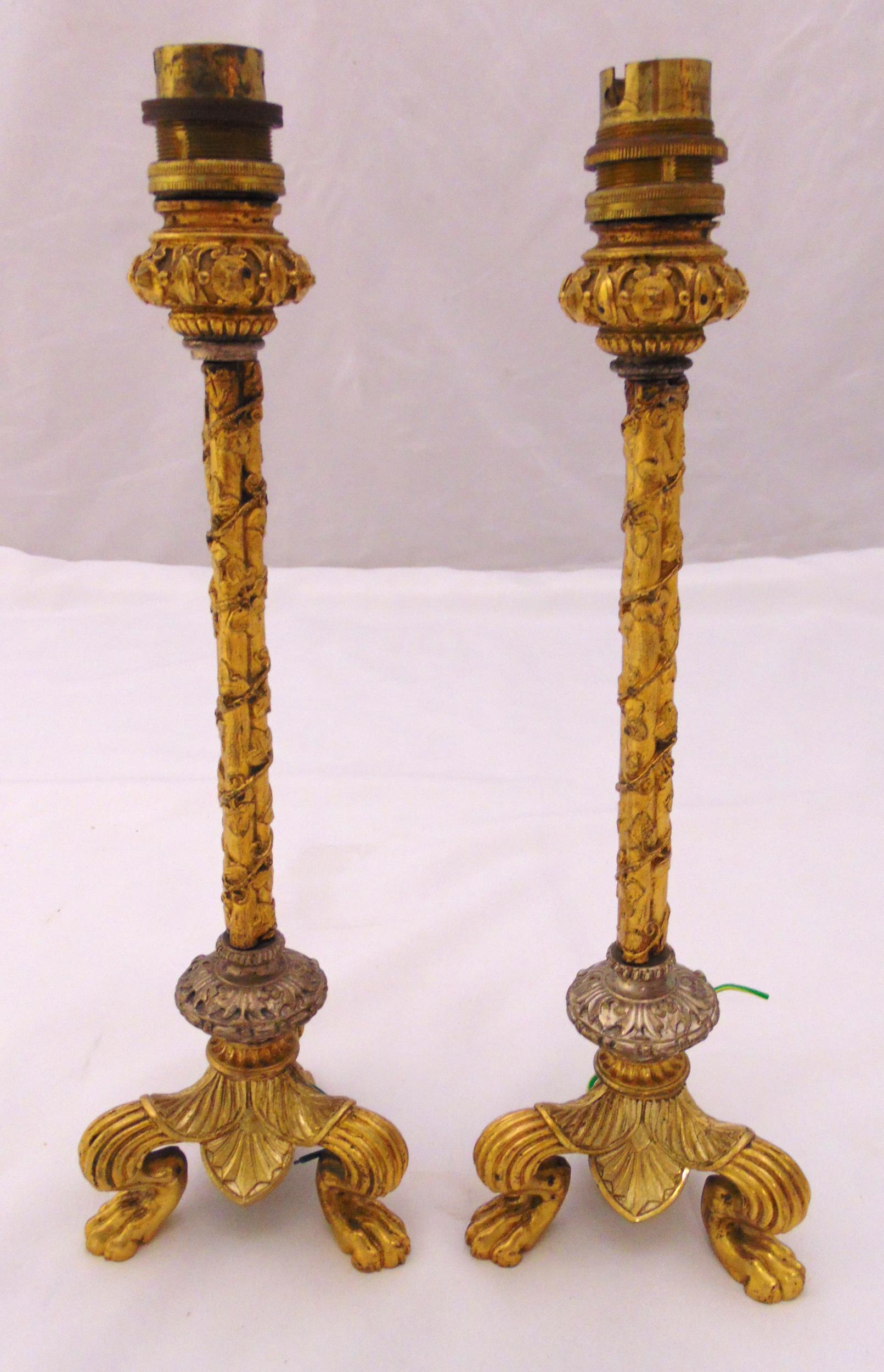 A pair of gilt metal table candlesticks, the ivy bound columns on triform claw feet, converted to