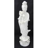 Chinese blanc de chine figurine of a deity holding a lotus flower, mounted on a raised base with