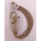 An Art Deco platinum ladies wristwatch with diamond bezel on a 9ct gold bracelet, approx total