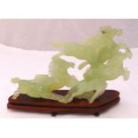 An oriental jadeite figural group of galloping horses on a hardwood stand to include original silk
