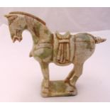 An oriental carved soapstone figurine of a Tang style horse on raised rectangular plinth, 20cm (h)