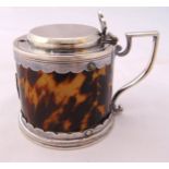 A faux tortoiseshell and silver plated mustard pot with angled handle and raised hinged cover, 6.5cm