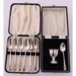 A cased set of hallmarked silver coffee spoons and a cased egg cup and spoon, approx total weight
