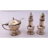 A three piece hallmarked silver condiment set and a condiment spoon