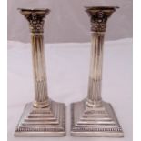 A pair of Victorian hallmarked silver Corinthian column table candlesticks on stepped square bases