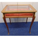 A continental rectangular Kingswood glazed display table with brass mounted hinged top on four
