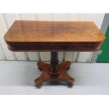 A Regency mahogany games table on fluted columnular support with quatrefoil stand on carved bun