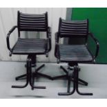 A pair of Olympian early 20th century barbers chairs with leatherette seats and foot supports