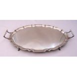 A hallmarked silver oval twin handled tray on hoof feet, marks for Barker Brothers Chester 1923,