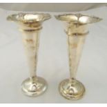 A pair of hallmarked silver vases, tapering cylindrical with everted shell shaped borders on