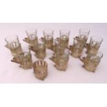 Twelve Persian white metal tea glass holders, to include the glasses and a matching white metal