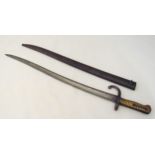 A continental late 19th century bayonet with brass handle and scabbard, 71cm (l)