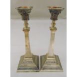 A pair of hallmarked silver table candlesticks, Corinthian column on stepped square bases with