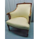 An Edwardian upholstered mahogany armchair on tapering rectangular legs