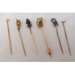 Six gold hat pins, the terminals in the form of enamelled figures and animals
