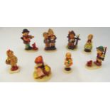 Eight Geobel figurines of children in various poses on oval bases