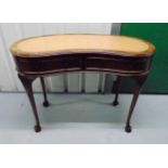 A late 19th century mahogany kidney shaped desk with two drawers and inset leather top on tapering