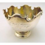 A hallmarked silver presentation bowl with scroll border on raised circular base, circa 1930 marks
