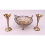 A hallmarked silver pierced three handled bonbon dish and two miniature vases, vase 10cm (h)