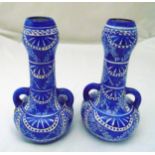 A pair of Middle Eastern two handled blue and white ceramic vases, geometric designs and two pierced