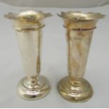 A pair of hallmarked silver vases, tapering cylindrical with everted borders on raised circular