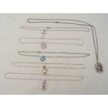 Six silver pendant necklaces to include a crucifix, a locket, rectangular framed arrows and three