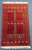 A Middle Eastern wool red ground carpet with repeating geometric patterns, 165 x 94.5cm