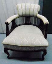 An early 20th century upholstered armchair on four scroll legs