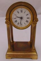 A late 19th century continental brass four column mantle clock, the white dial with Roman