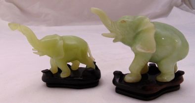 A pair of carved jadeite stylised elephants on shaped hardwood stands, tallest 10cm (h)