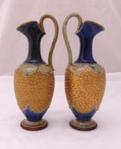 A pair of Doulton Lambeth ewers, with loop handles on raised circular base, marks to the bases, 33.