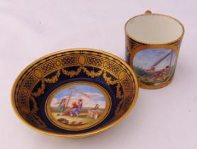 Sevres cup and saucer decorated with figures by a sailing boat within gilded borders, marks to the