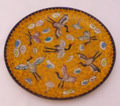 A Chinese cloisonné dish orange ground decorated with stylised storks and clouds, 25cm (dia)