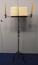 An early 20th century wrought iron music stand with double candle holders on three outswept legs, 72