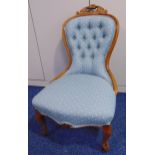 An upholstered button back mahogany ladies chair on cabriole legs and castors