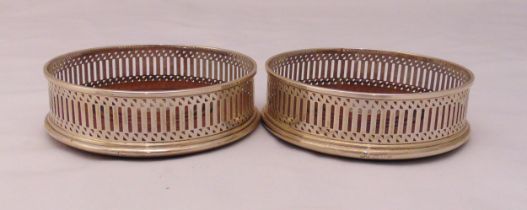 A pair of hallmarked silver coasters, bar pierced sides and turned wooden base, London 1990