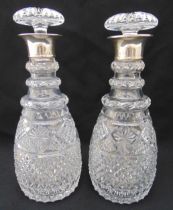 A pair of Regency style cut glass decanters with drop stoppers and silver collars, 28cm (h)