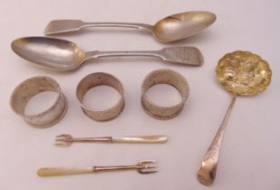A quantity of hallmarked silver to include two spoons, three napkin rings and a pair of pickle forks