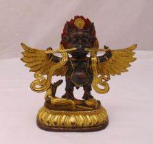 A Tibetan gilded bronze Buddha with wings holding a snake and standing on a mermaid all on a