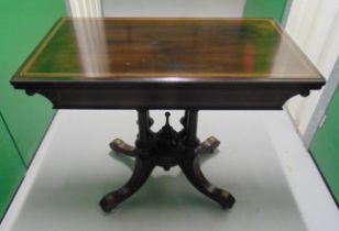 A late 19th century ebonised rectangular games table with satinwood inlays on four outswept legs,