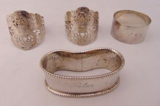Three hallmarked silver napkin rings and a white metal napkin ring (4)